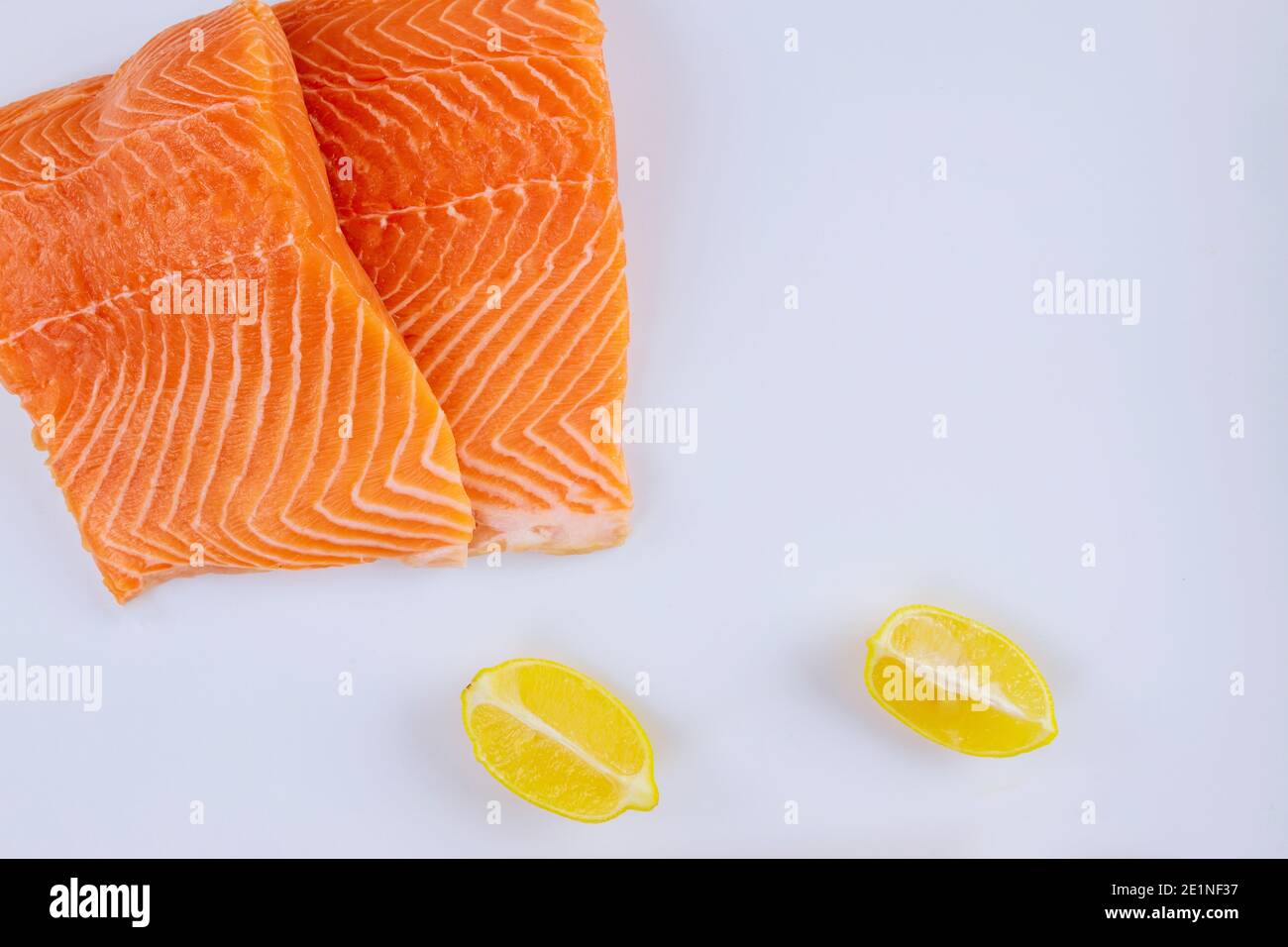 Two raw salmon fillets with lemon on white background Stock Photo - Alamy