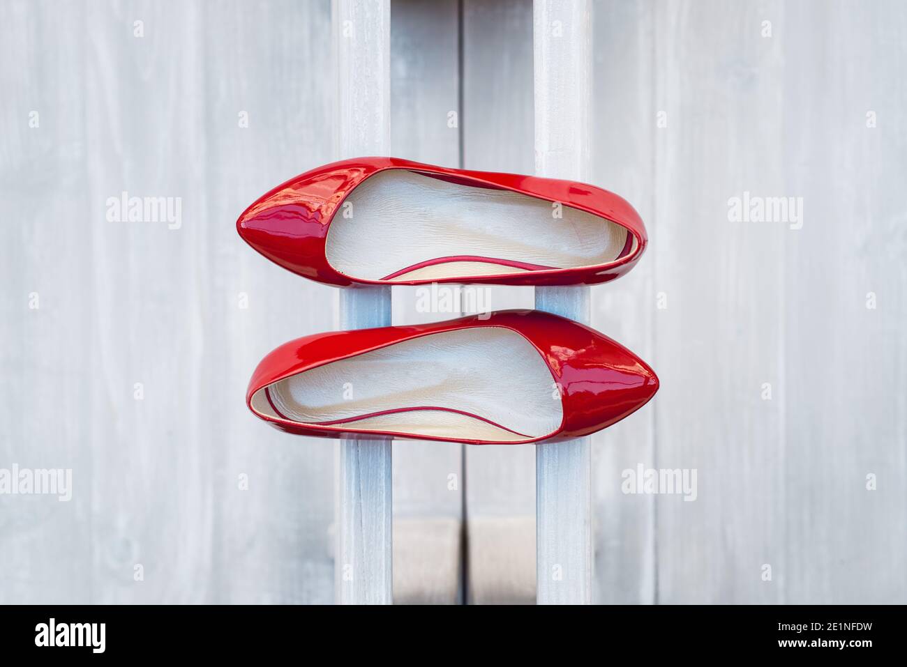 Leather red women's shoes on a white wooden shelf. Fashion, minimal fashion concept, women's shoes, accessories. red women's lacquered leather shoes Stock Photo