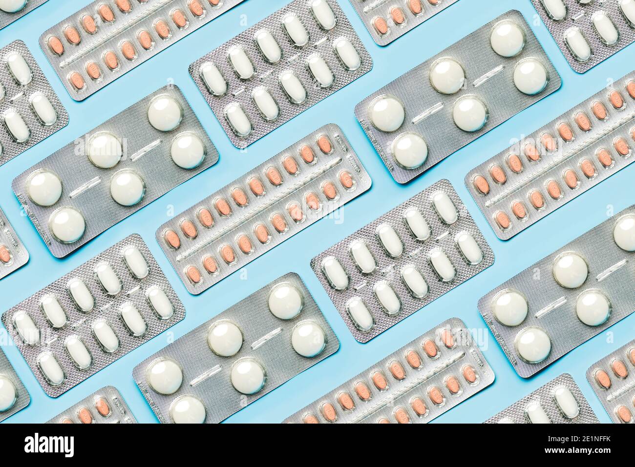 Geometric pattern made with blister with white tablets and painkillers on blue background. Concept of medicine Stock Photo