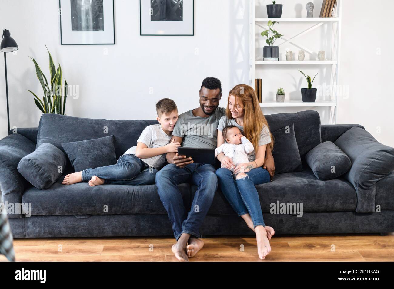 A multiracial family on the couch at home Stock Photo
