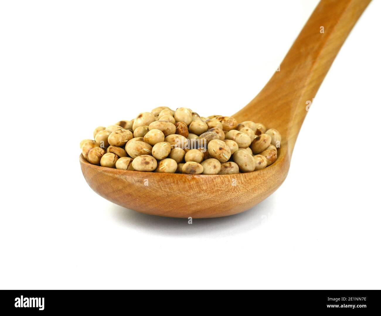 Roasted soybeans (soy nuts) in a wooden spoon isolated on white