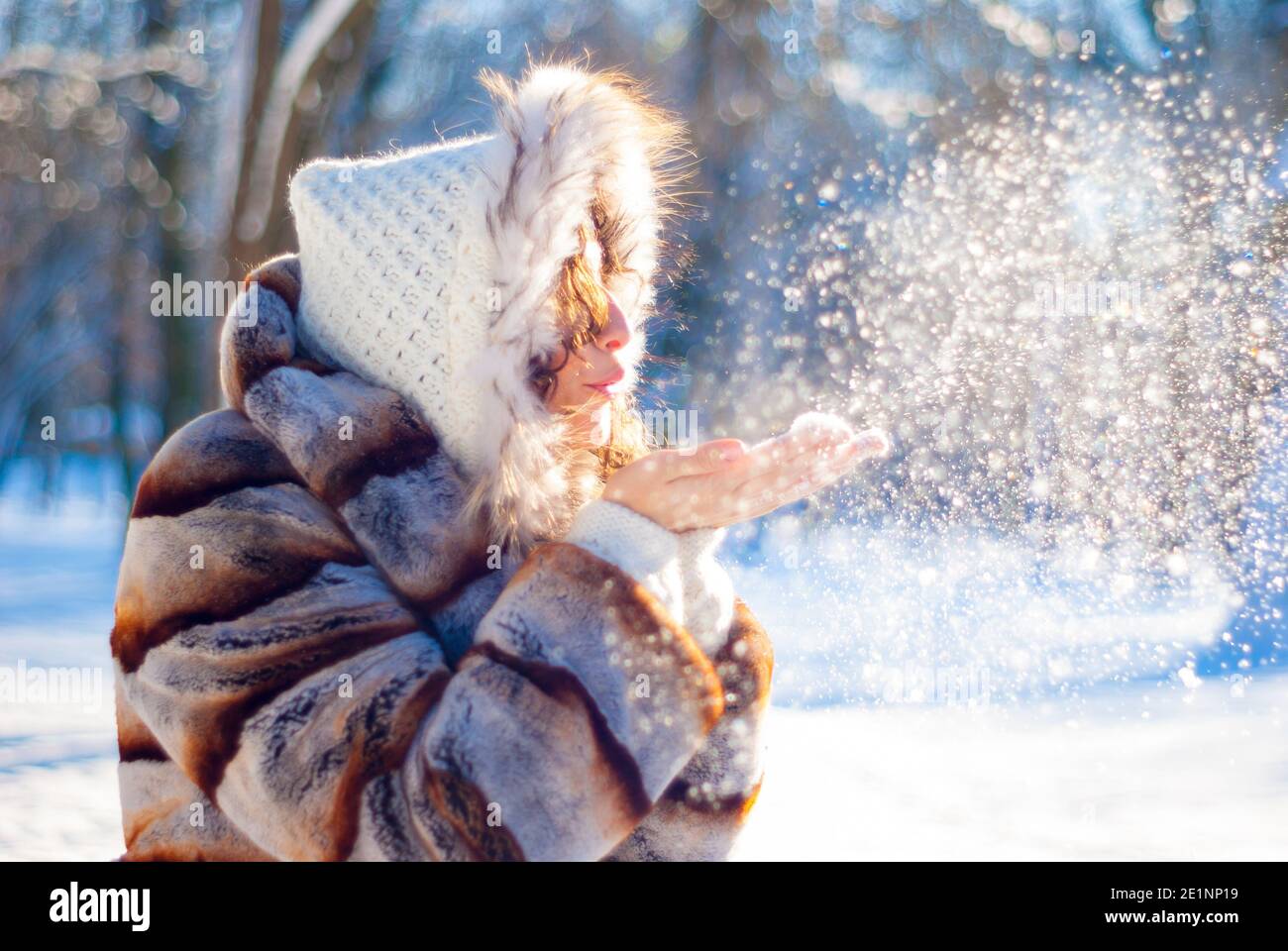 Young girl blows snow from her palms Stock Photo