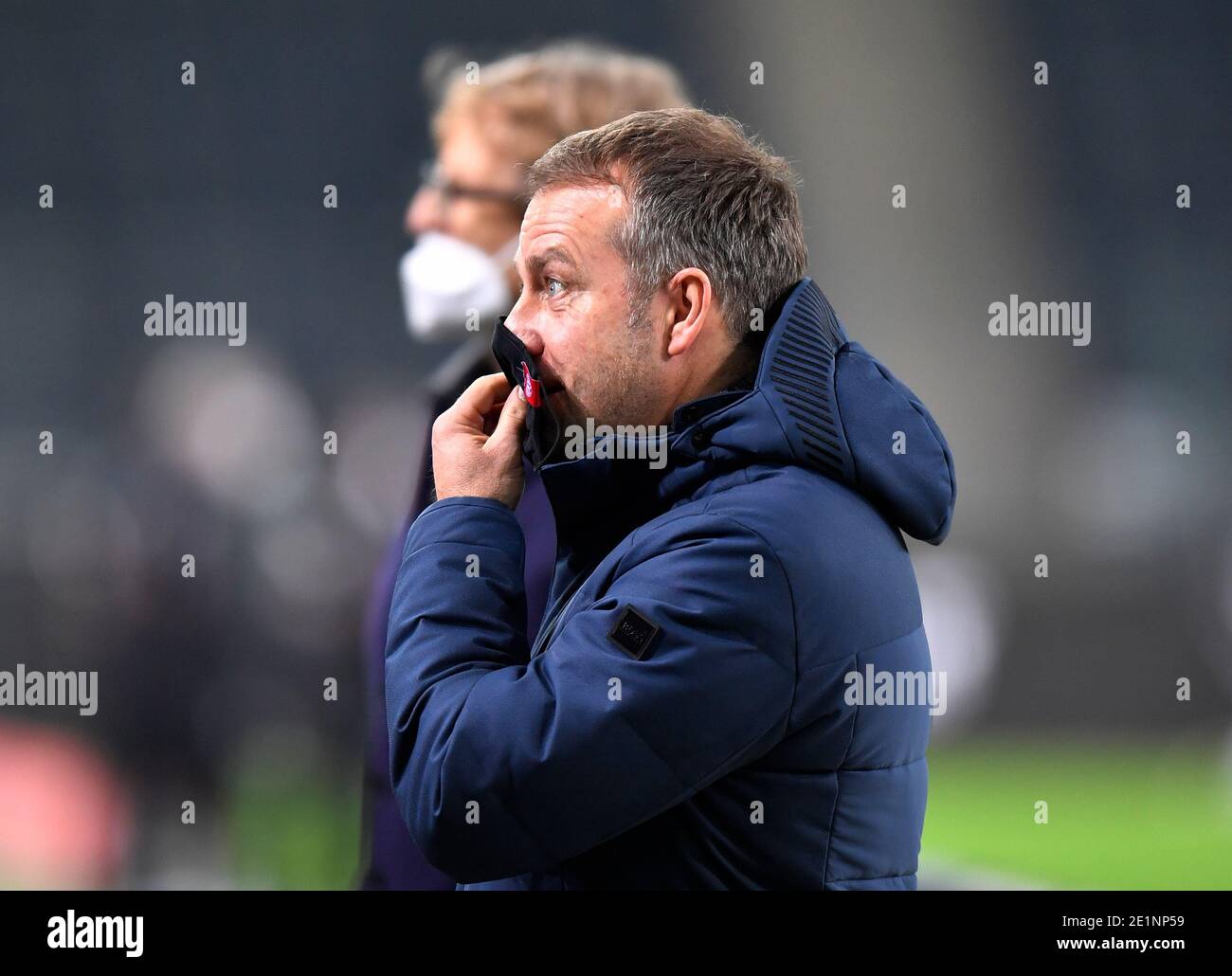 08 January 2021, North Rhine-Westphalia, Mönchengladbach: Football:  Bundesliga, Borussia Mönchengladbach - FC Bayern München, Matchday 15 at  the stadium in Borussia Park. Bayern's coach Hansi Flick holds a mouth-nose  covering in front