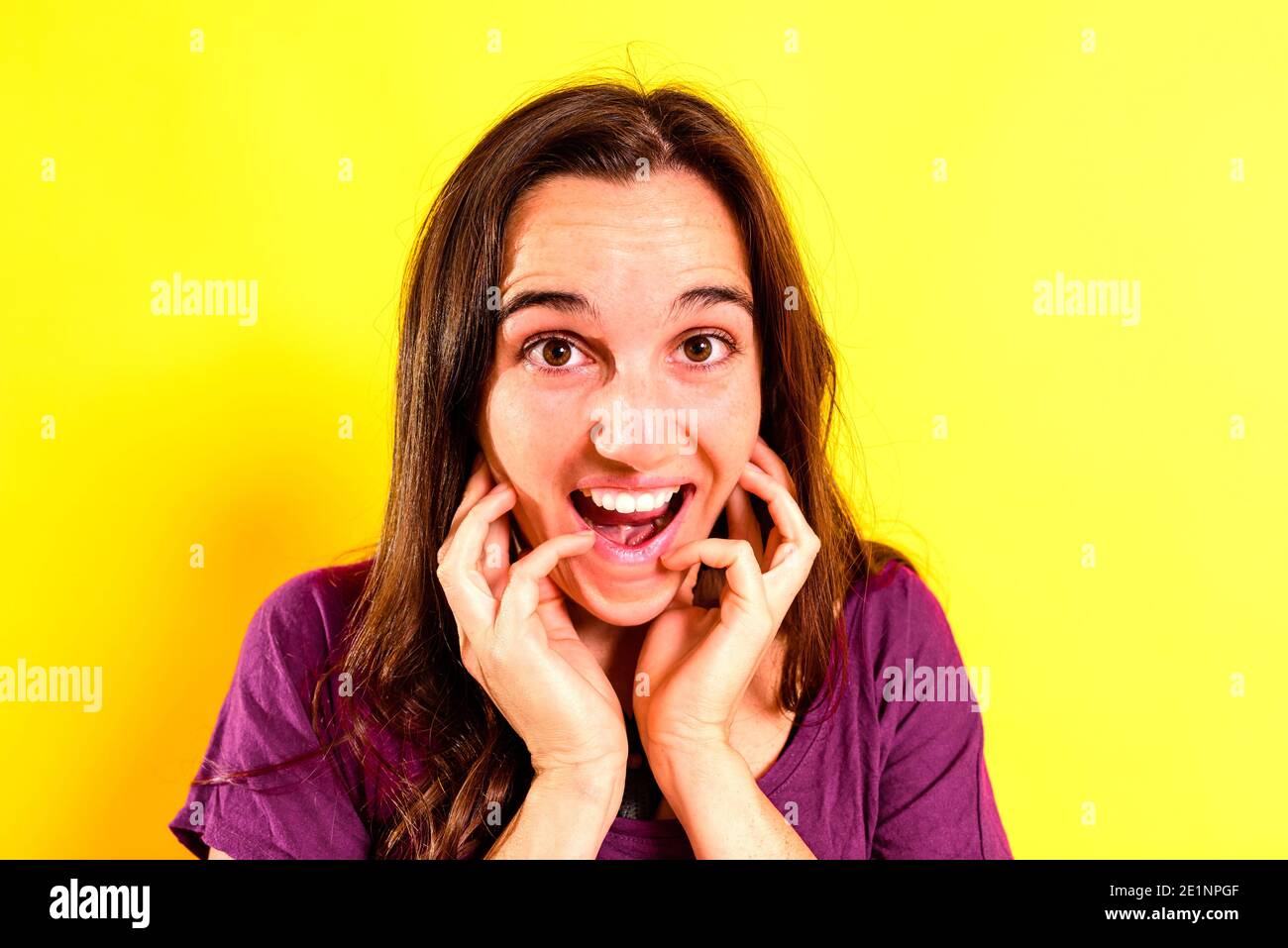 Portrait of a young woman with scared and shocked expression with surprise, fear and excited face, on isolated background. Stock Photo