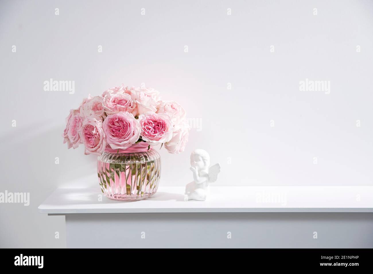 Rose White Pink O'hara in the glass transparent vase with figurine of bird  and the smal candle. The pink box with valentine gift is on the fireplace  Stock Photo - Alamy