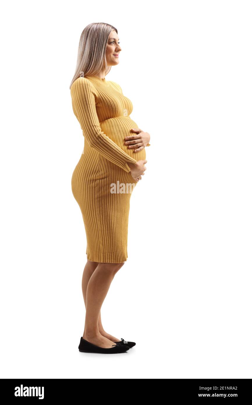 Pregnant woman in a yellow dress holding her belly isolated on white background Stock Photo