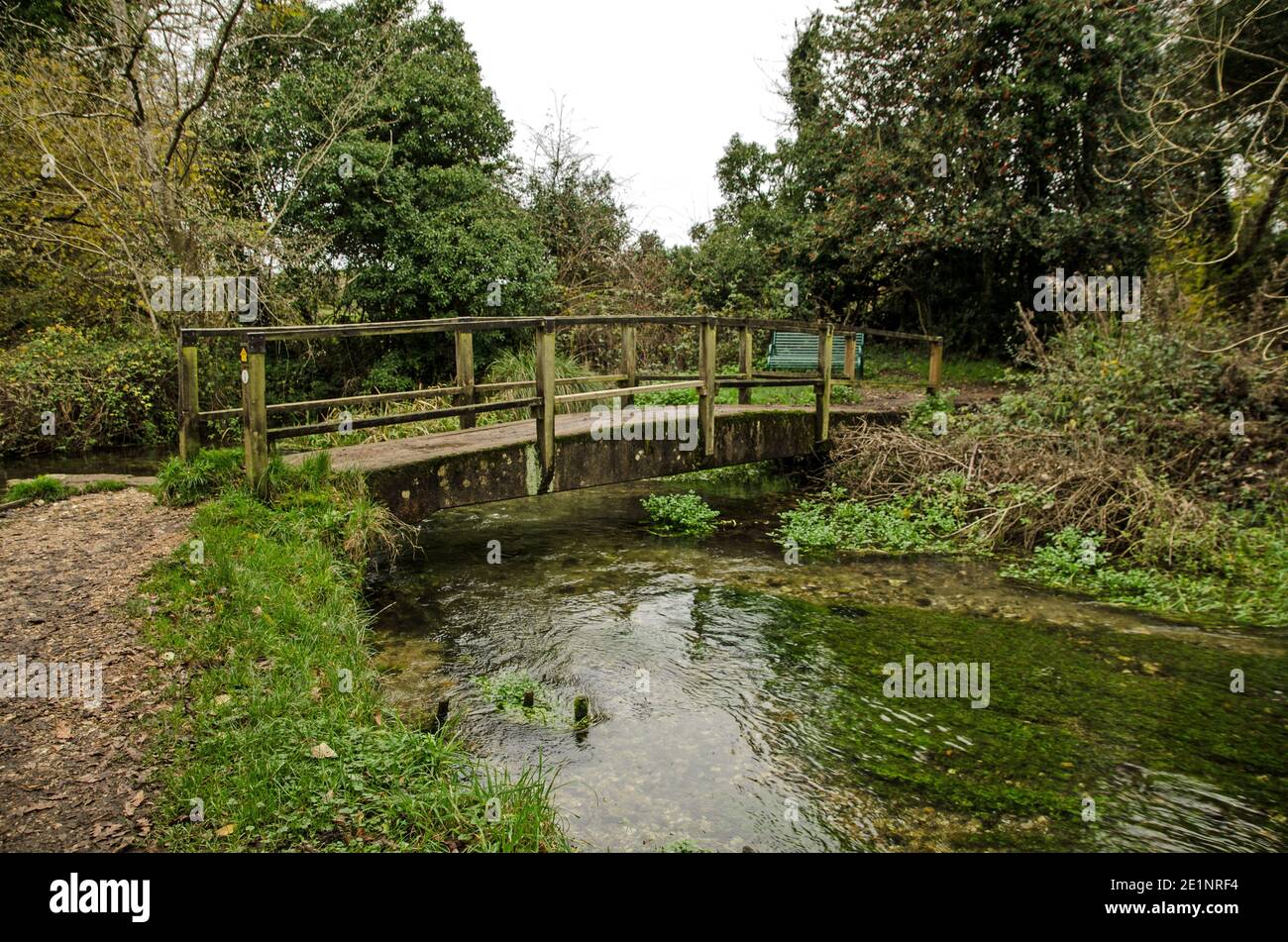 Footbridge over the River Itchen in the village of Itchen Stoke in Hampshire on a cloudy autumn day. Stock Photo