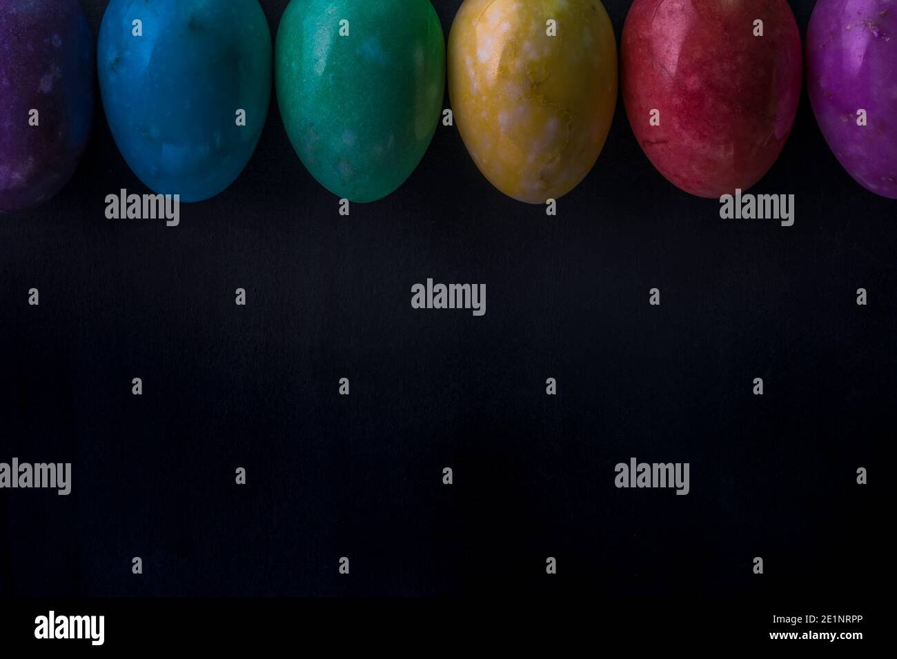 Easter multicolored eggs from stones on a dark background. Stock Photo