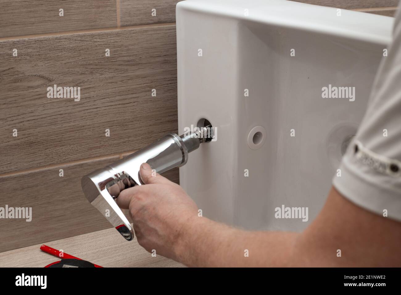 Installing a bathroom sink on a wooden countertop. Fitting the mixer