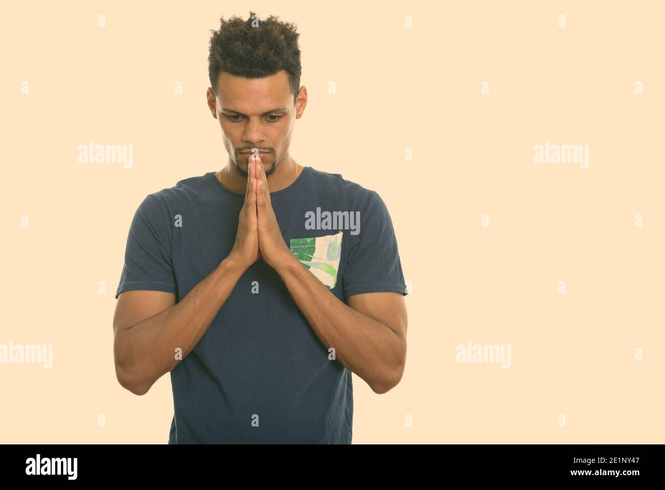 Studio shot of young African man greeting with hands together Stock ...