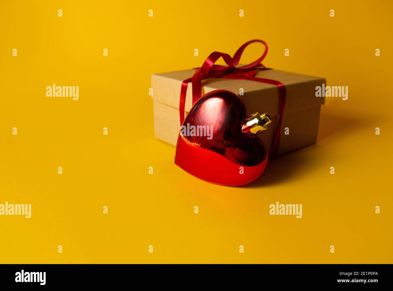 gift with red heart on yellow background Stock Photo