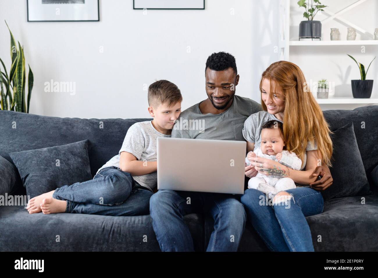 A multiracial family on the couch at home Stock Photo
