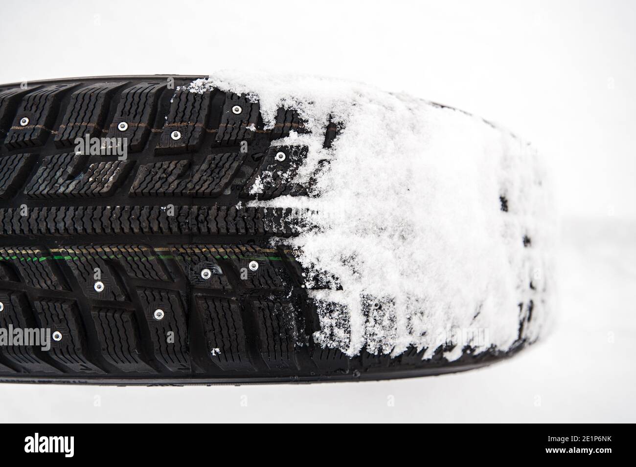 winter car studded tire on snow with shallow depth of field Stock Photo