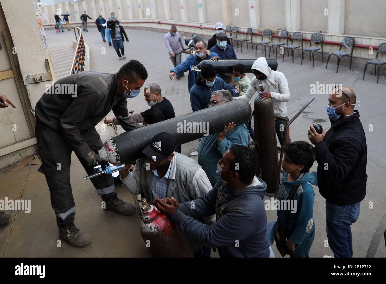 Cairo, Egypt. 5th Jan, 2021. Workers carry oxygen cylinders at a factory for producing oxygen in Cairo, Egypt, Jan. 5, 2021. TO GO WITH 'Feature: Oxygen cylinder consumption soaring amid Egypt's 2nd wave of COVID-19' Credit: Ahmed Gomaa/Xinhua/Alamy Live News Stock Photo