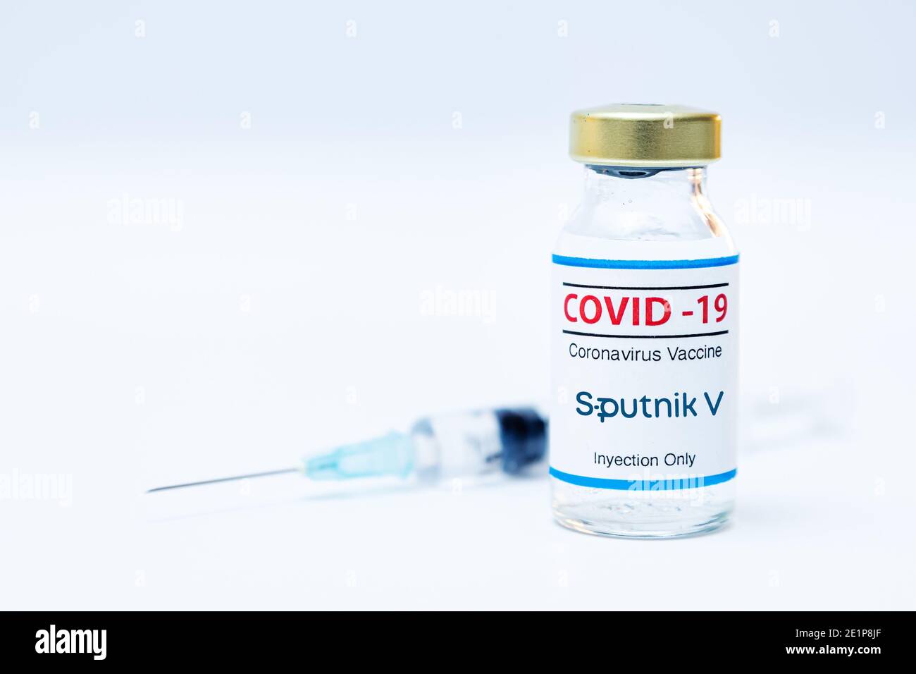 Bottle of coronavirus vaccine with the Sputnik V logo and syringe background. Stock Photo