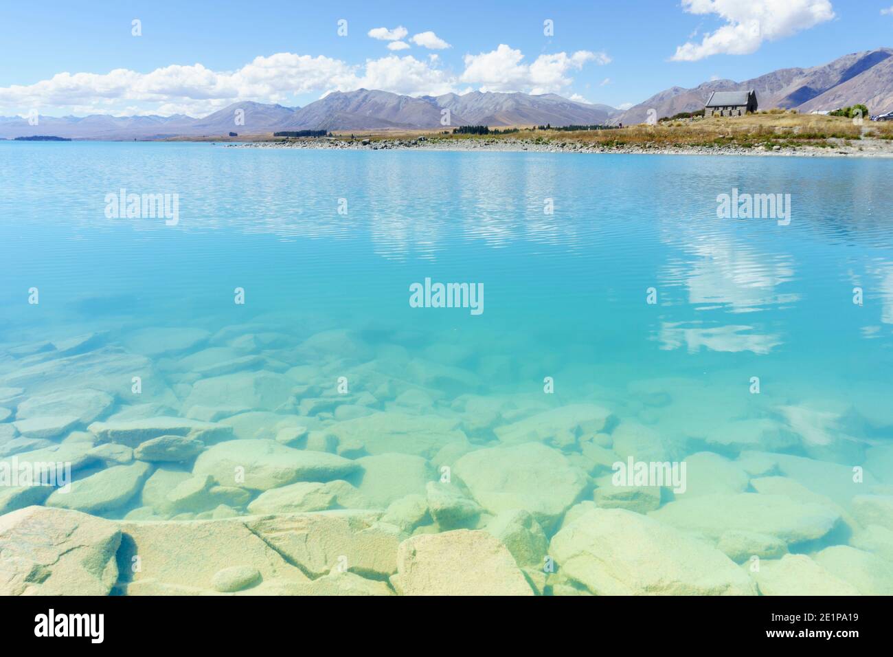 View across Tturquoise water of Lake Tekapo to distant otherside Stock