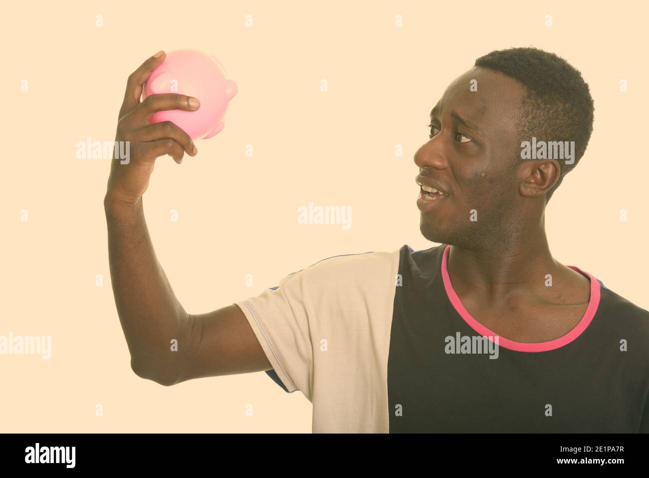 Shocked African man holding empty piggy bank Stock Photo - Alamy