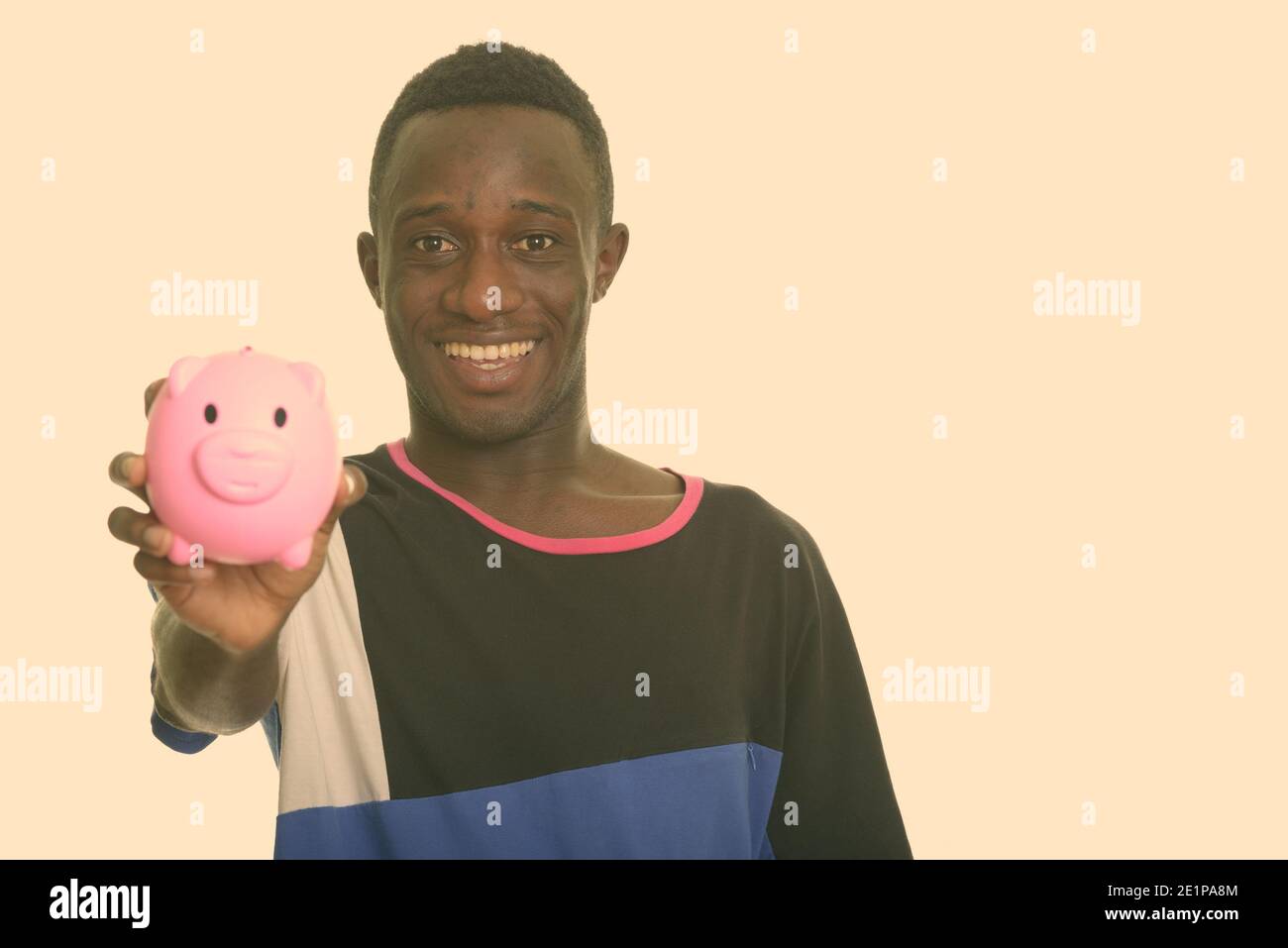 Happy African man smiling holding piggy bank Stock Photo - Alamy