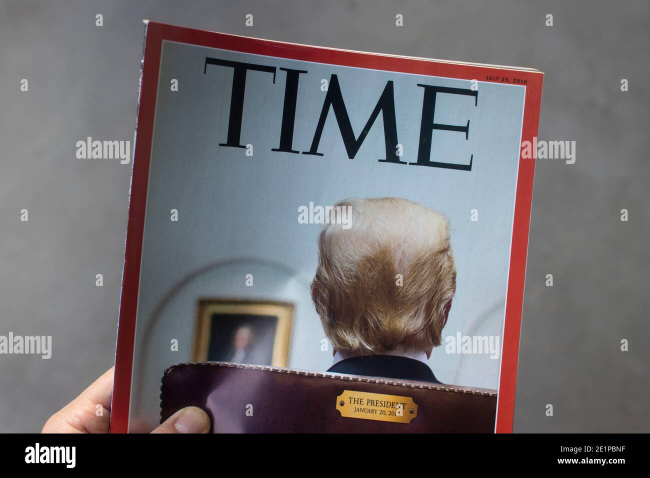 Hand holding a 2016 issue of TIME magazine with President Trump on the cover. Stock Photo