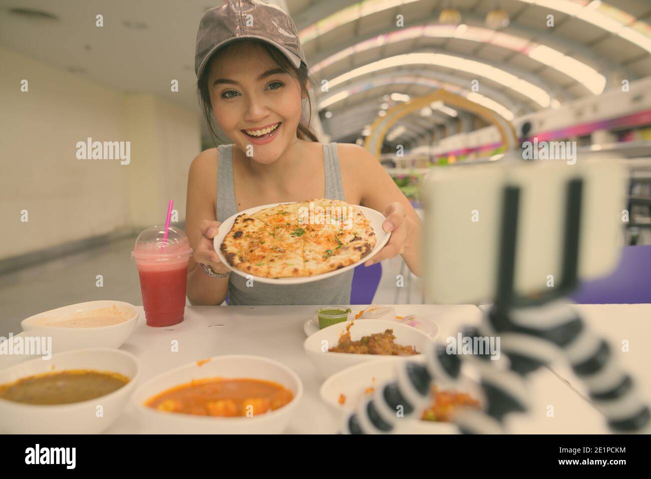 Young beautiful Asian tourist woman enjoying Indian cuisine at the restaurant in Bangkok city Stock Photo