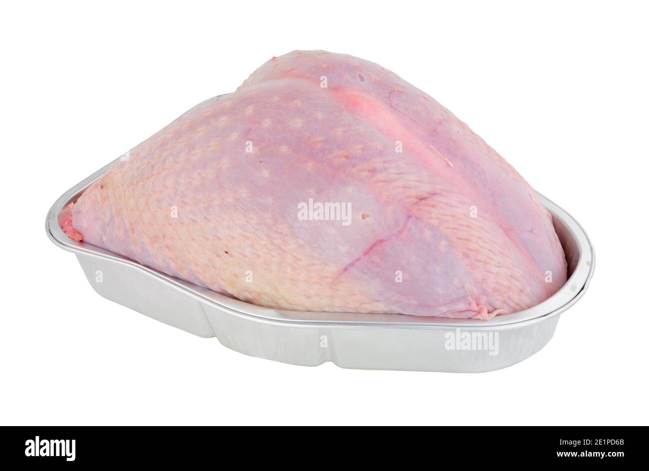Whole raw turkey crown meat in a foil roasting tray isolated on a white