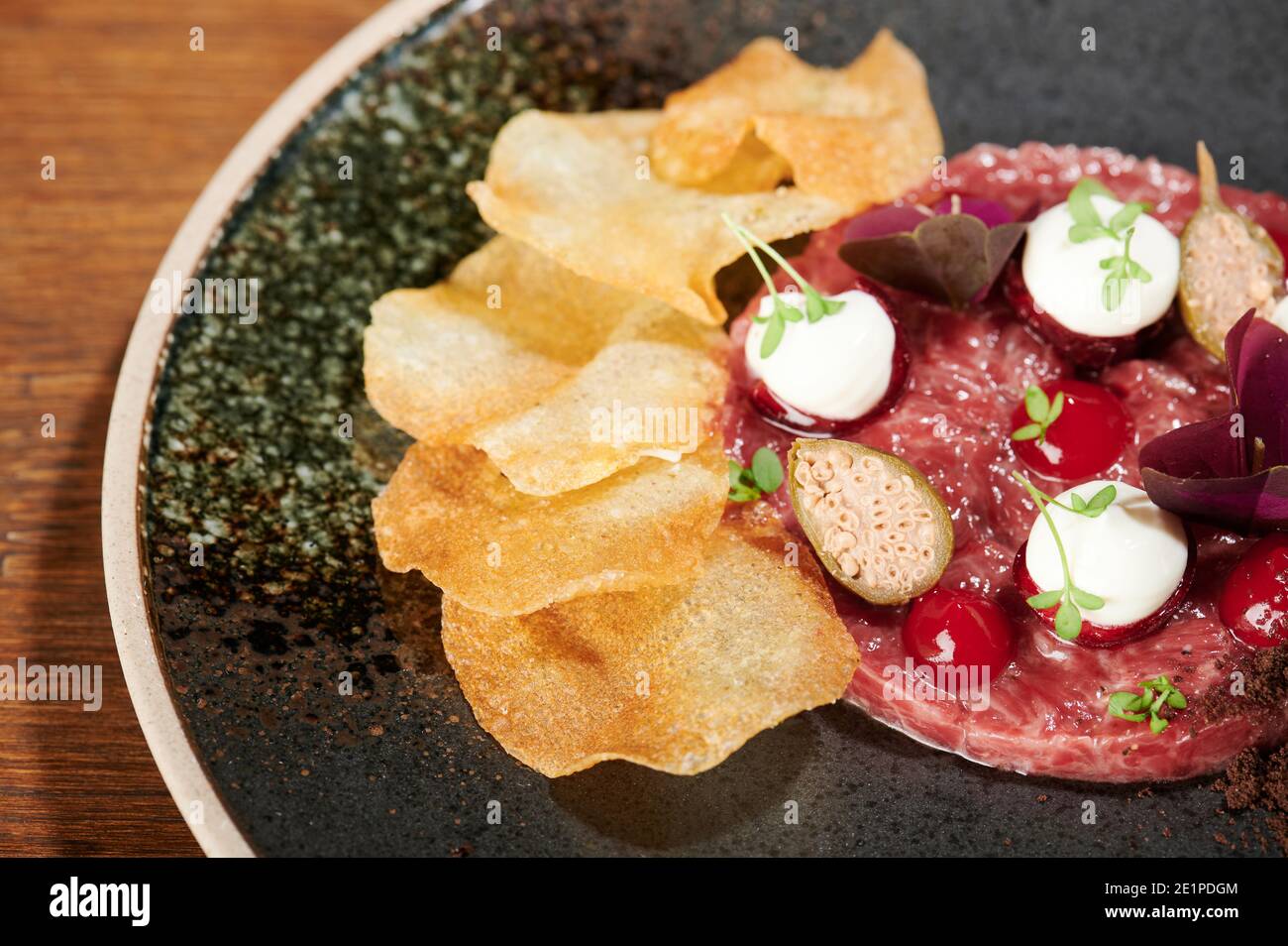 Delicious tartare meal with chips and tomato close up view Stock Photo