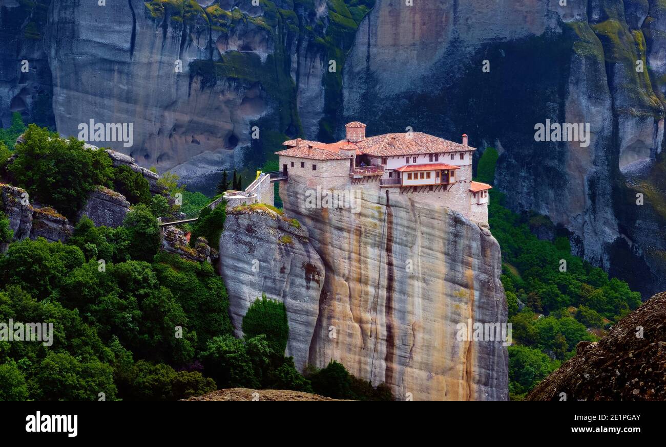 Close view of Moni Agias Varvaras Roussanou nunnery and spectacular massive rocky pillars of Meteora, Thessaly, Greece and rich foliage. Stock Photo