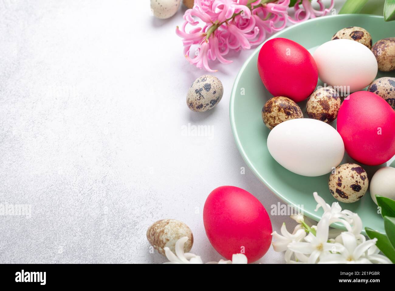 Spring composition. Green mint plate with easter eggs, on stone background. Copy space for text - Image Stock Photo