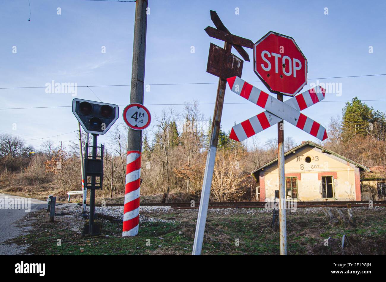 old-rusty-warning-sign-and-new-stop-sign-at-ungated-unmanned-train