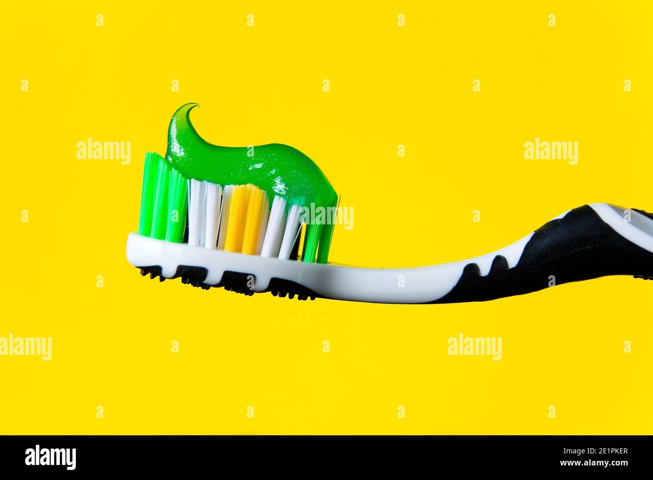 Green toothpaste lies beautifully on a toothbrush. Prevention of dental diseases. Stock Photo