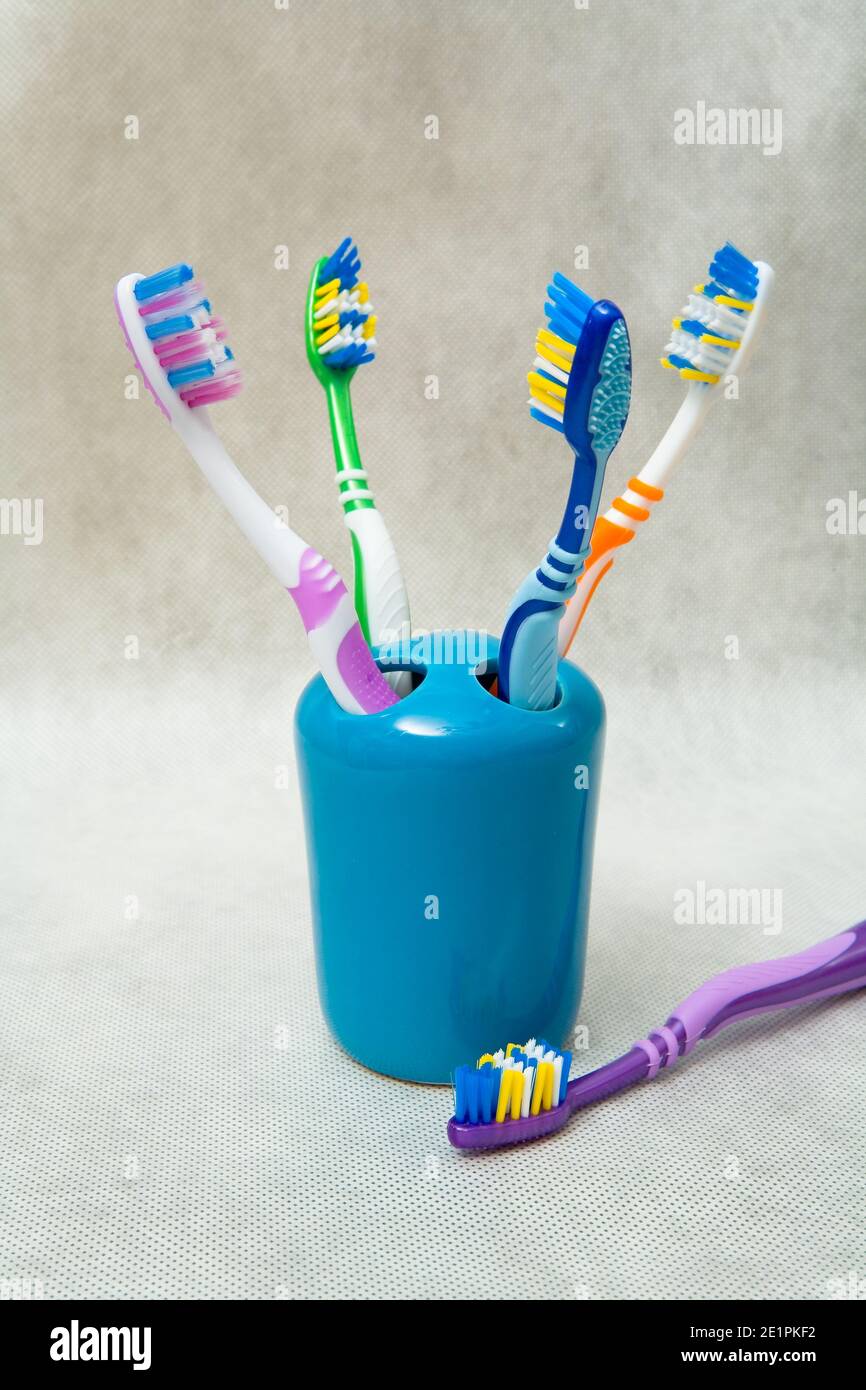 Multi-colored toothbrushes stand in a special glass. Still life. Stock Photo