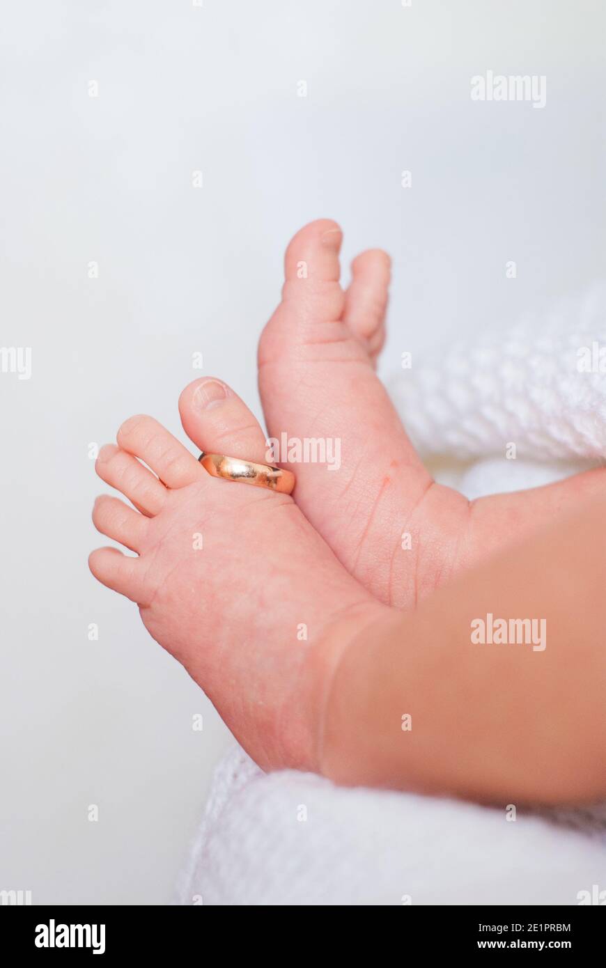 Wedding ring on the thumb of small children's legs on white background Stock Photo