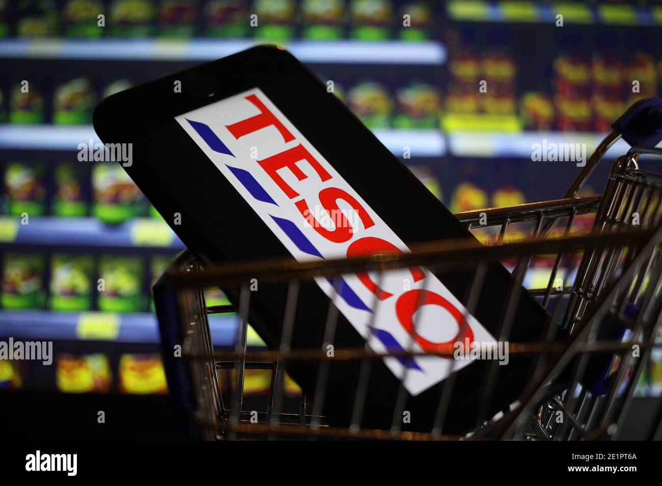 Viersen, Germany - May 9. 2020: Close up of mobile phone screen in shopping cart modell with logo lettering of us american Tesco supermarket chain (fo Stock Photo