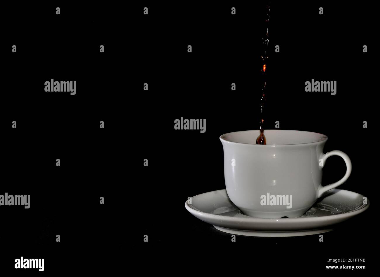 cup of coffee being poured with black background Stock Photo