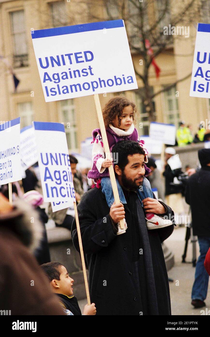 The Islamaphobia rally organised by moderate Muslim groups, father with child holding protest placard United against incitement, at muslim rally against publication of danish cartoon. The Jyllands-Posten Muhammad cartoons controversy began after the Danish newspaper Jyllands-Posten published 12 editorial cartoons Stock Photo