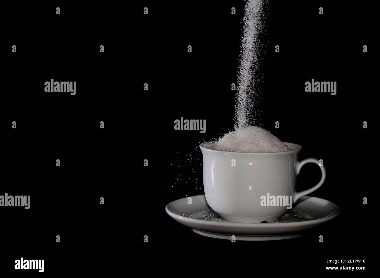 full white cup with sugar on black background Stock Photo