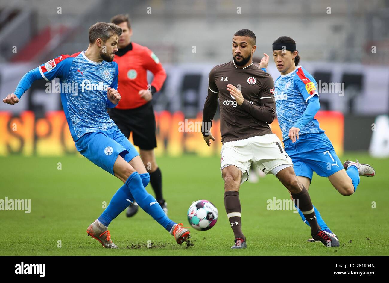 Hamburg, Germany. 09th Jan, 2021. Football: 2nd Bundesliga, Matchday 15, FC St. Pauli - Holstein Kiel at Millerntor Stadium. St.Pauli's Daniel-Kofi Kyereh (m) fighting for the ball with Kiel's Stefan Thesker (l) and Jae-sung Lee. Credit: Christian Charisius/dpa - IMPORTANT NOTE: In accordance with the regulations of the DFL Deutsche Fußball Liga and/or the DFB Deutscher Fußball-Bund, it is prohibited to use or have used photographs taken in the stadium and/or of the match in the form of sequence pictures and/or video-like photo series./dpa/Alamy Live News Stock Photo