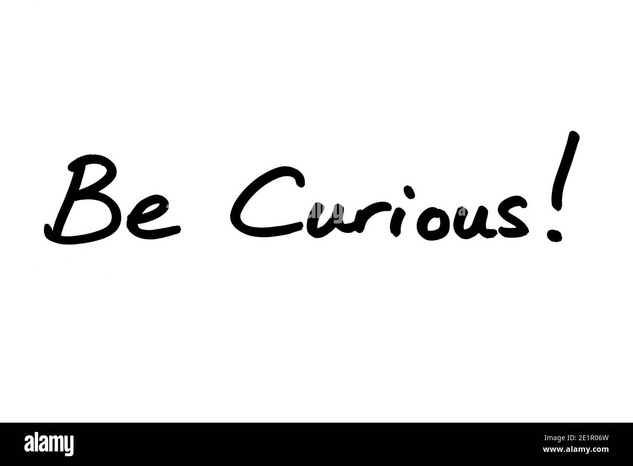 Be Curious! handwritten on a white background. Stock Photo