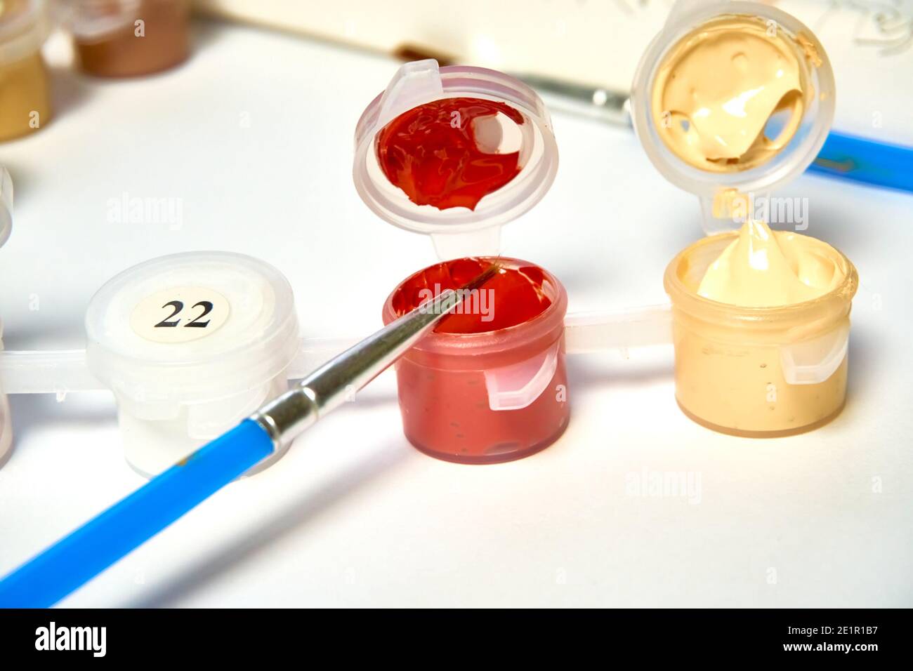 Numbered containers of paint for coloring drawings by numbers on canvas