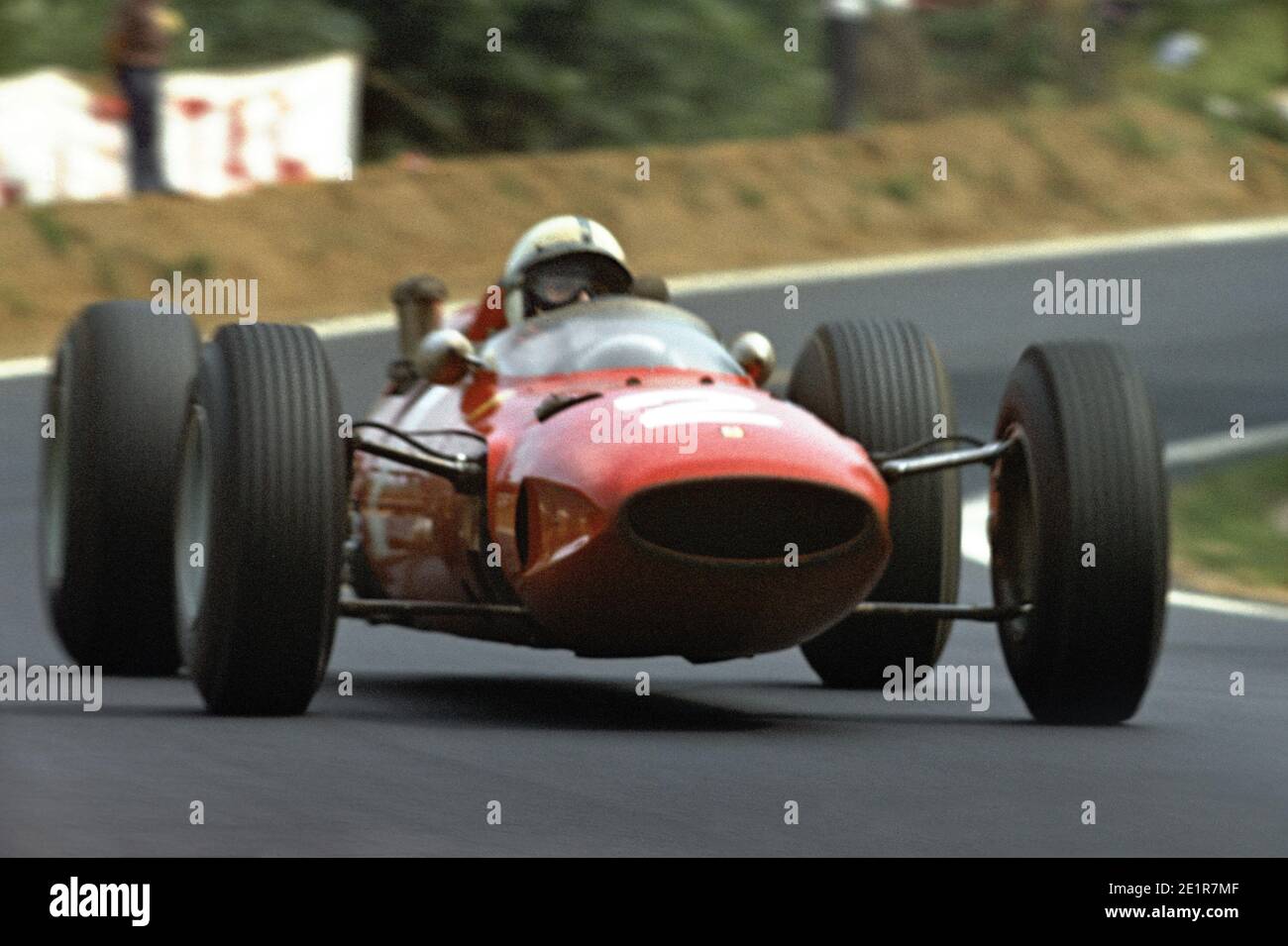 John SURTEES driving Ferrari F1 car in full speed during 1965 Grand Prix de France, in Charade circuit near Clermont-Ferrand. Stock Photo