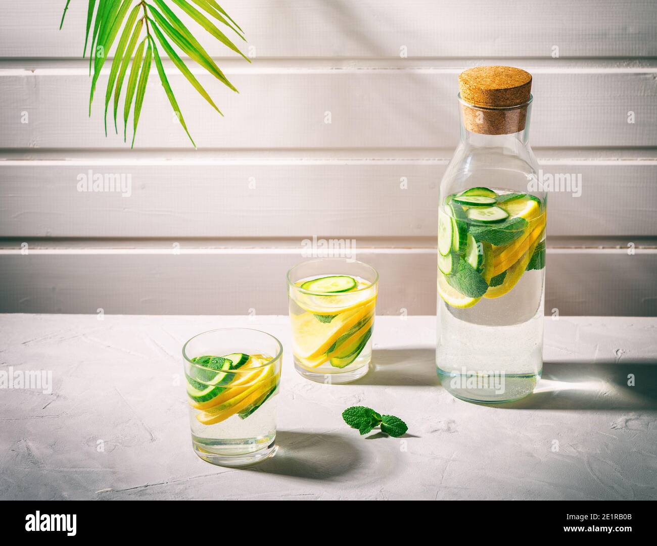Sassy water for detox infused with lemon, cucumber and mint in glasses on white background. Healthy lifestyle concept. Hard shadows. Stock Photo