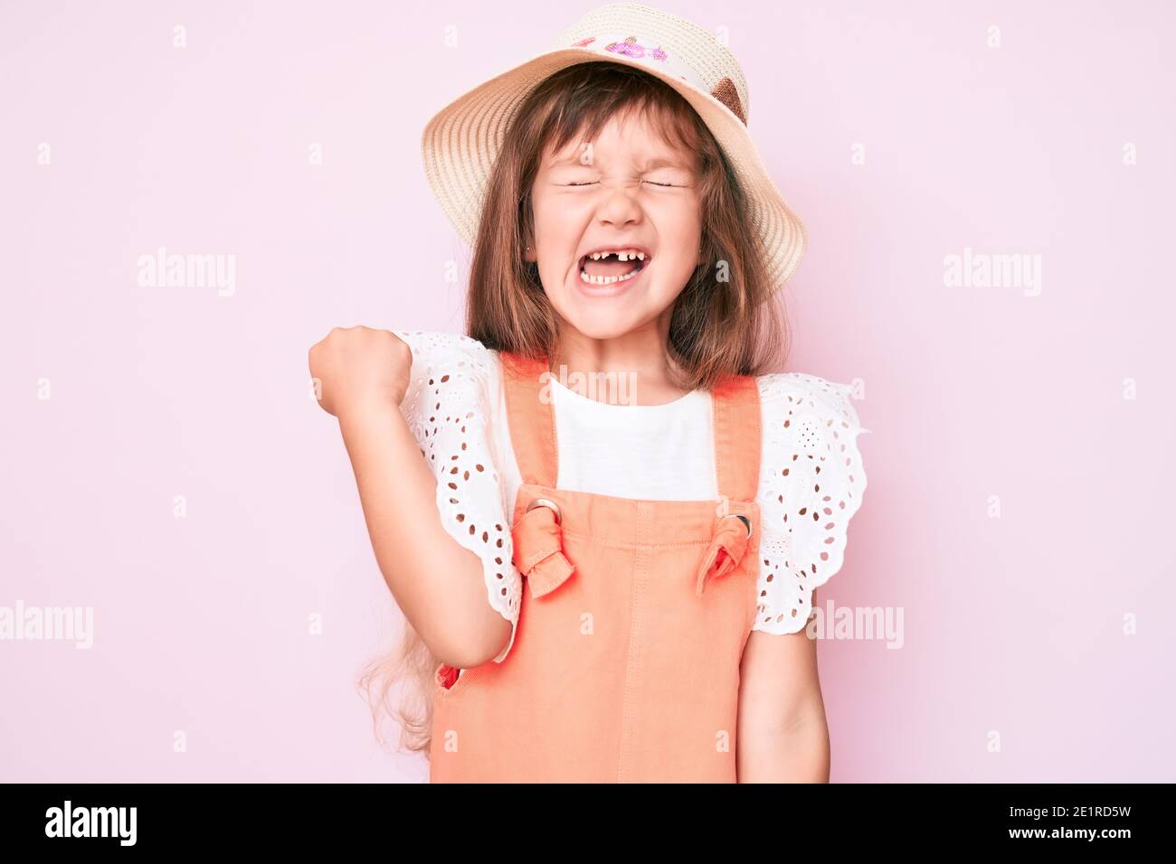 Little caucasian kid girl with long hair wearing spring hat celebrating ...