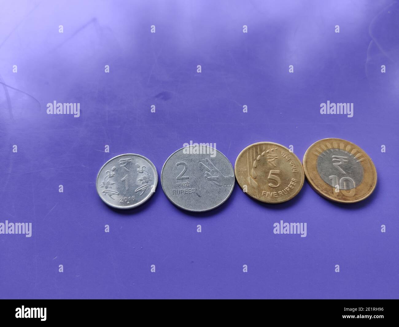 New designed Indian currency coins of rupees one, two, five, and ten kept  on blue background closeup shot Stock Photo - Alamy