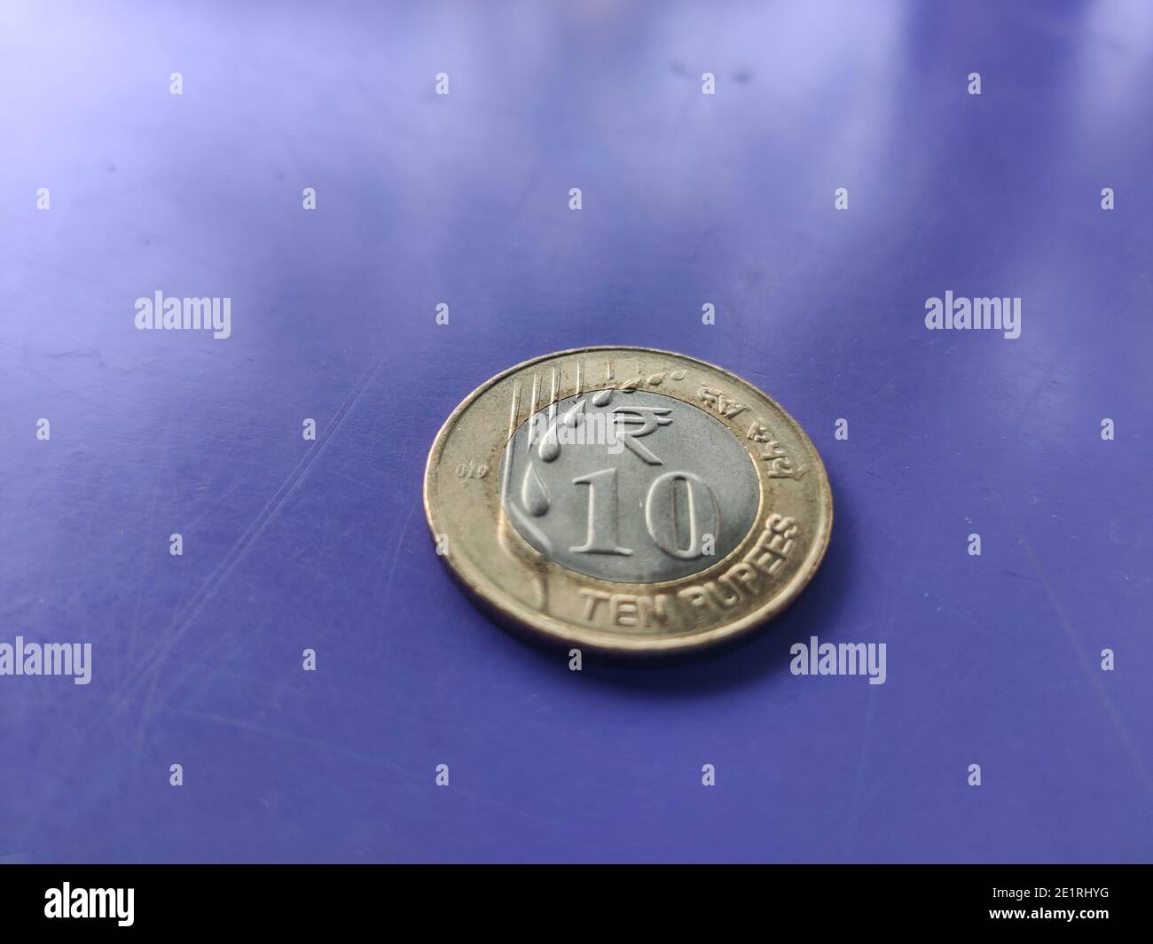 Indian currency coins of rupees ten front side with new design and pattern  kept on blue background closeup shot Stock Photo - Alamy