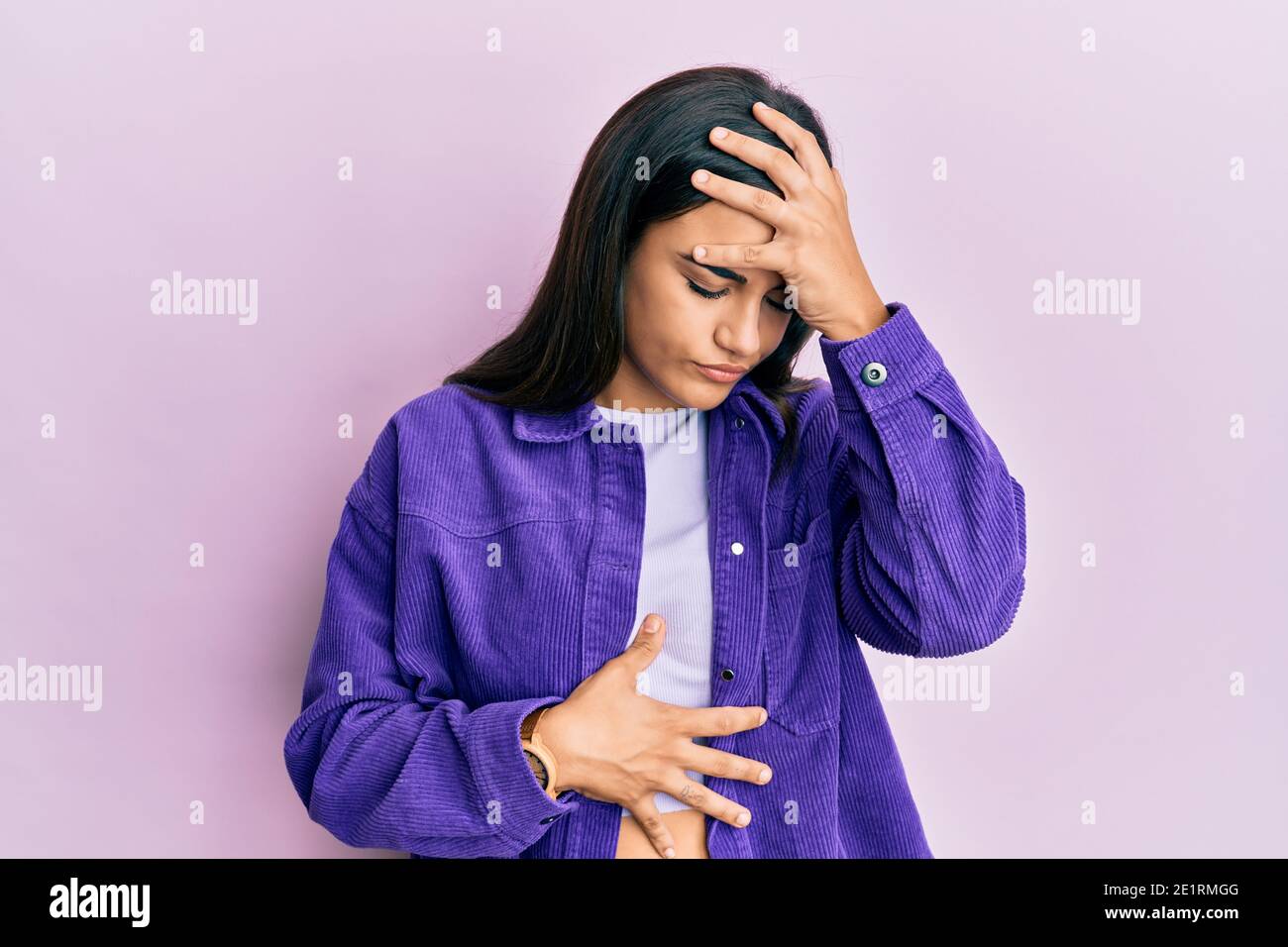 Young woman wearing casual clothes touching forehead for