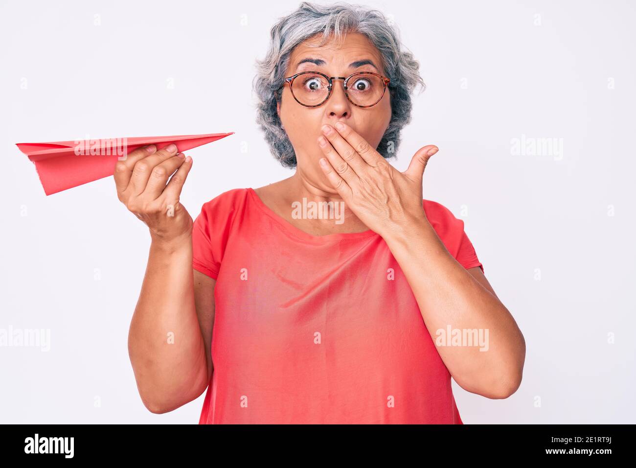 Afraid Paper Senior hispanic grey- haired woman holding paper airplane covering ...