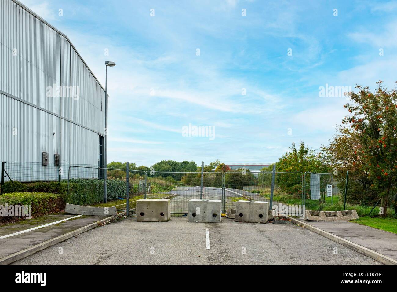 Concrete boulders blocking road on industrial estate in Middlewich Cheshire UK Stock Photo