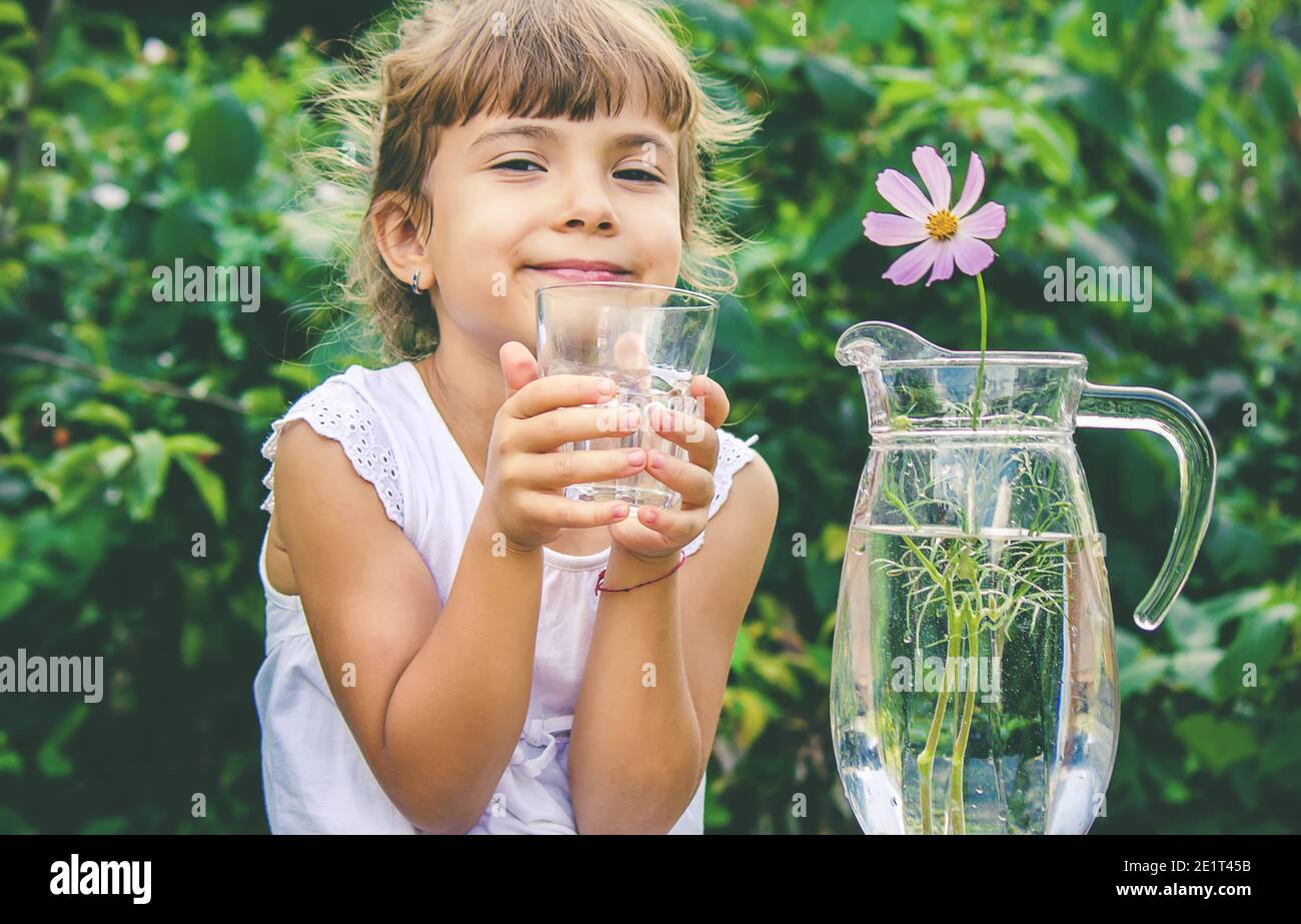 The child drinks clean water in summer. Selective focus. People Stock