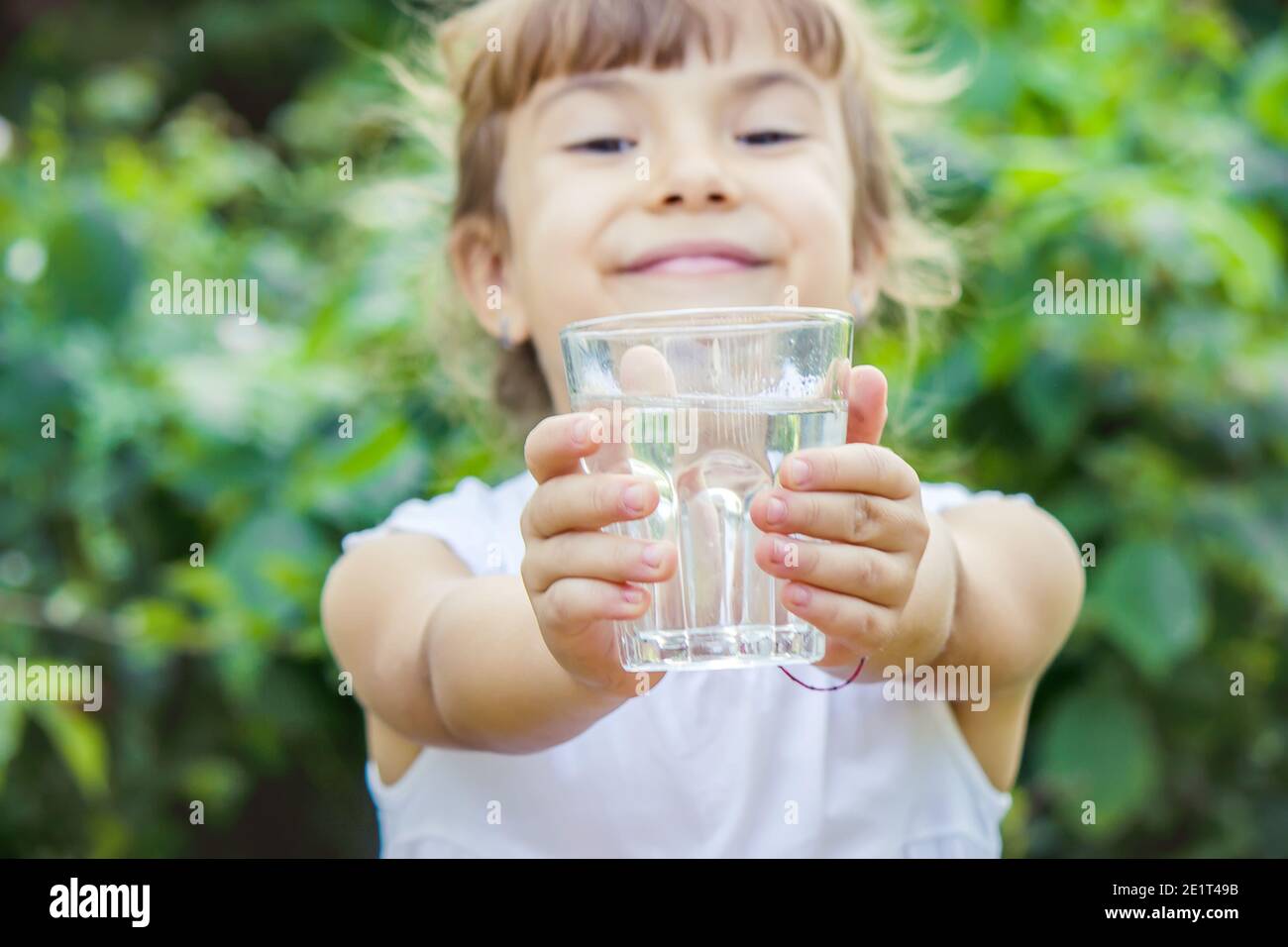 The child drinks clean water in summer. Selective focus. People Stock