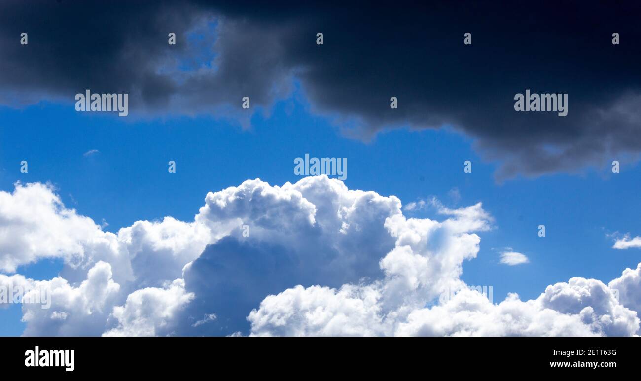 Sky with white and black clouds and sun. Beautiful background, copy